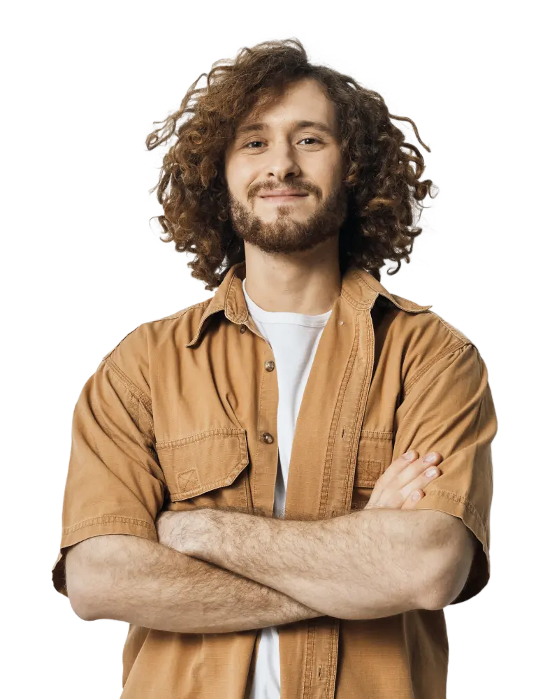 Smiling young man with curly hair wearing a casual outfit.
